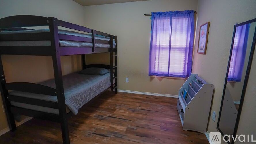 A room with bunk beds and a window with curtains.