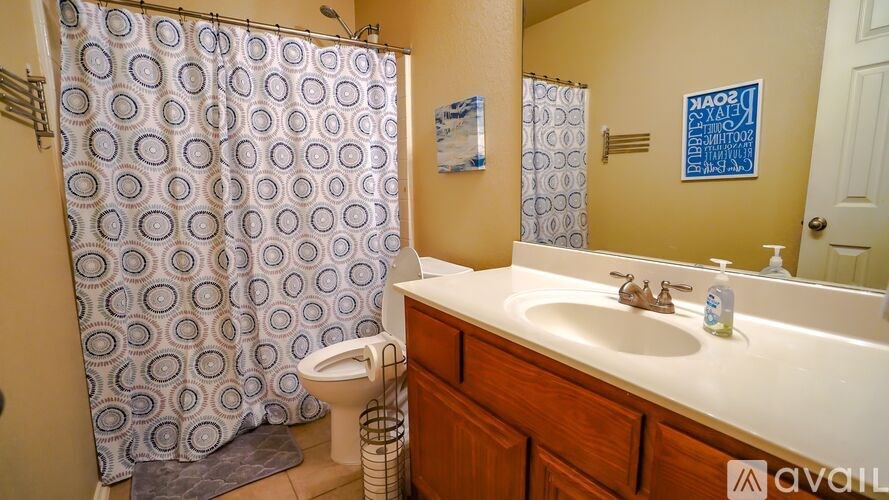 A bathroom with a patterned shower curtain and a white sink.