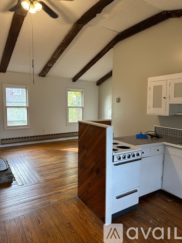 A kitchen with wooden floors and white appliances.