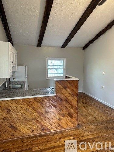 A room with wooden flooring and a window.