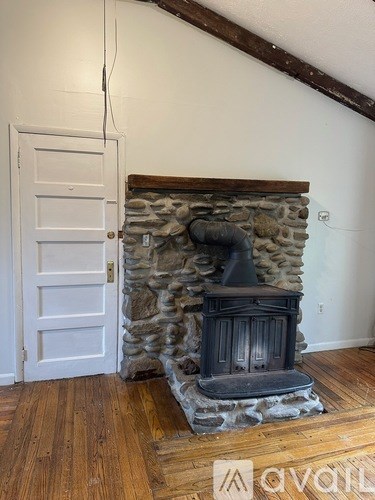 A white door is next to a stone fireplace.