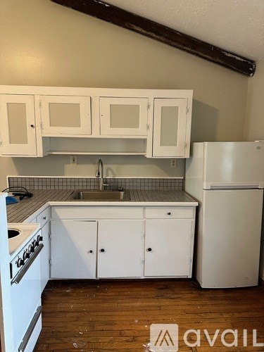 A kitchen with white appliances and cabinets.