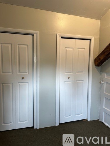 Two white doors in a room with a logo on the bottom right.