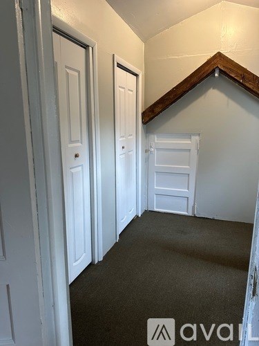 A hallway with white doors and a carpeted floor.