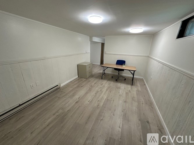 A room with a wooden floor and a table with chairs.