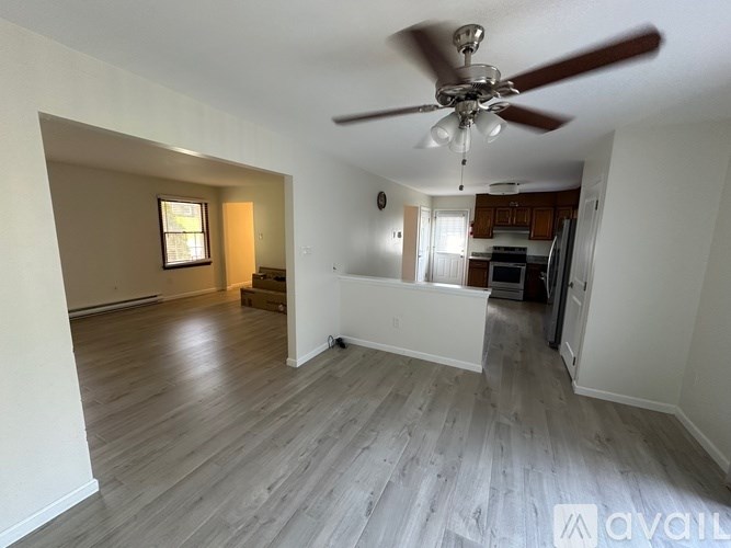 A room with a ceiling fan and wooden flooring.