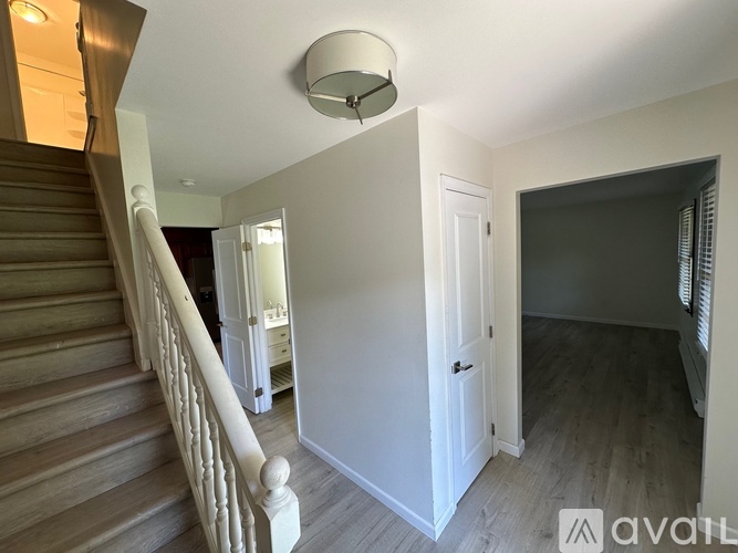A staircase with a light on the ceiling and a door on the right.