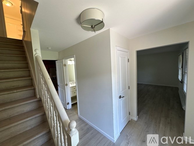 A staircase with a light on the ceiling and a door on the right.