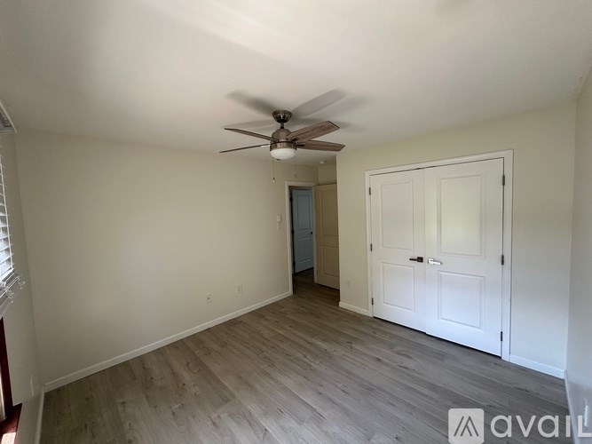 A room with a ceiling fan and a door.