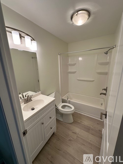 A bathroom with a toilet, sink, and bathtub.