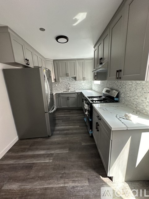 A kitchen with a refrigerator, stove, and cabinets.
