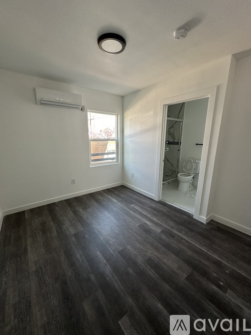A room with a wooden floor and a window.