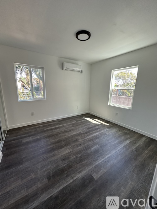 A room with a window and a picture on the wall.