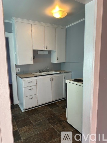 A kitchen with white cabinets and a dishwasher.