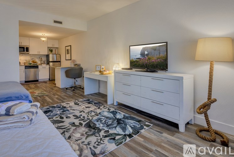 A bedroom with a bed, dresser, and a television on the wall.