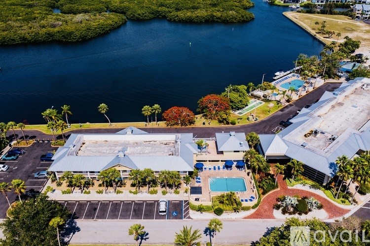 An aerial view of a resort with a swimming pool and palm trees.