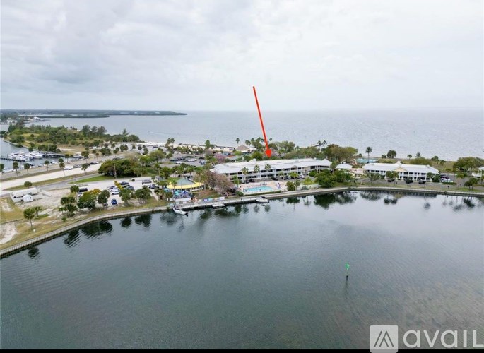 A large body of water with a dock and buildings in the distance.