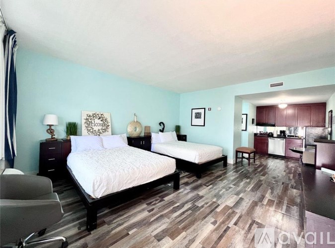 A bedroom with two beds and a chair.