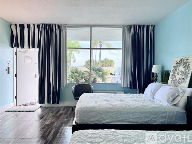 A bedroom with a large bed and a view of the outside through the window.