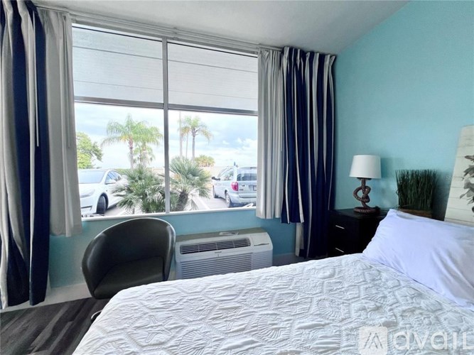 A bedroom with a large bed and a view of the street outside.