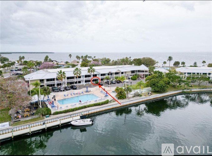 A large building with a pool and a boat docked in front of it.