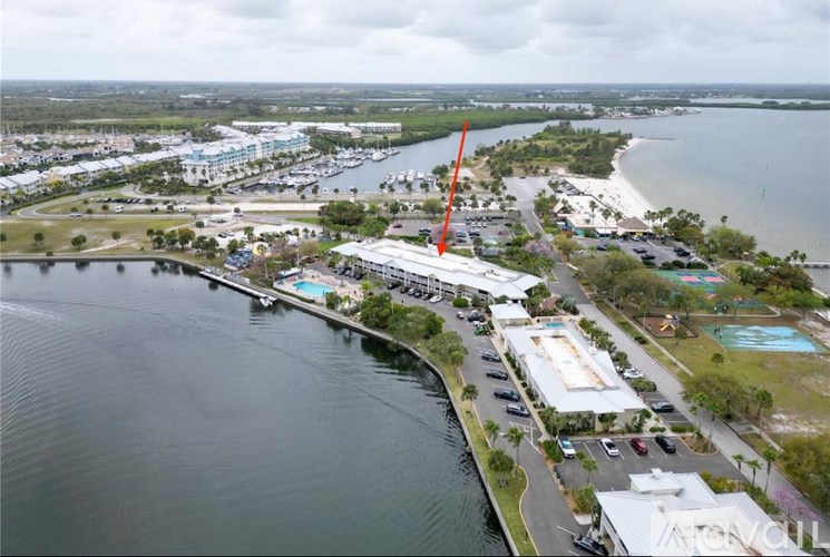 An aerial view of a beachfront area with a large body of water and a parking lot.