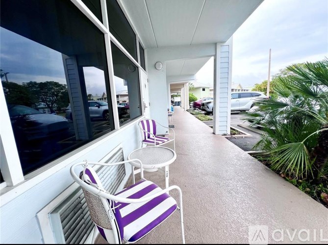 A patio with purple and white striped chairs and a table.