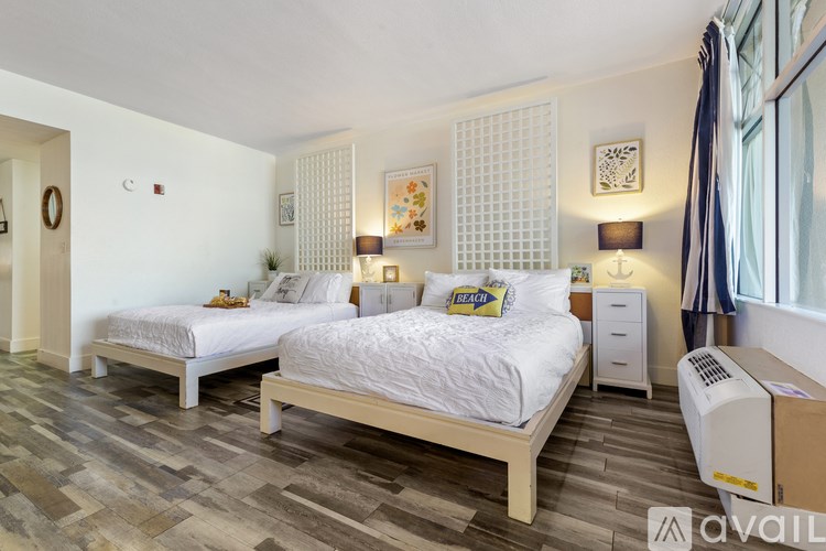 A bedroom with two beds, a nightstand, and a heater.