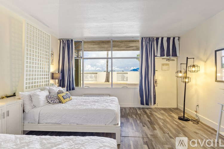 A bedroom with a large bed and a view of the ocean.