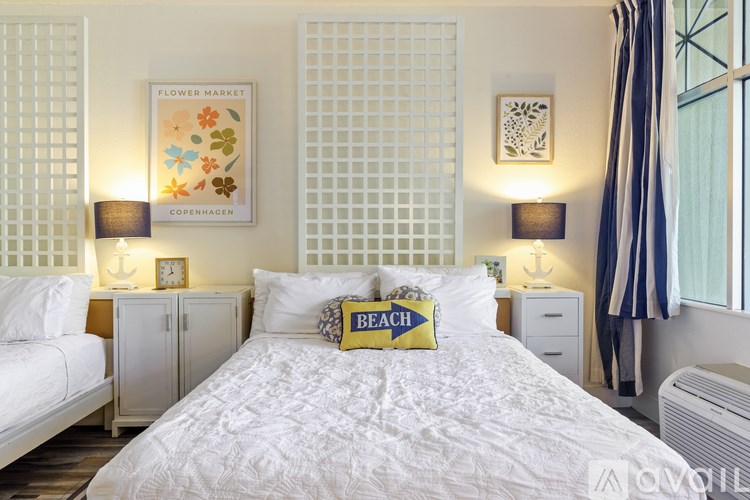 A bedroom with a large bed and a picture of a flower market in Copenhagen.