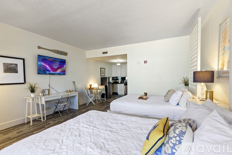 A bedroom with a large bed and a flat screen TV mounted on the wall.