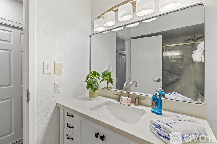 A bathroom with a white sink and a mirror above it.