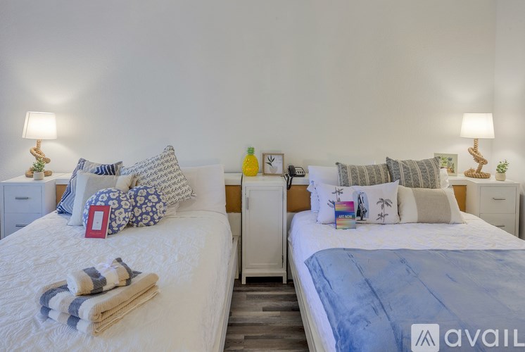 Two beds with pillows and blankets in a room.