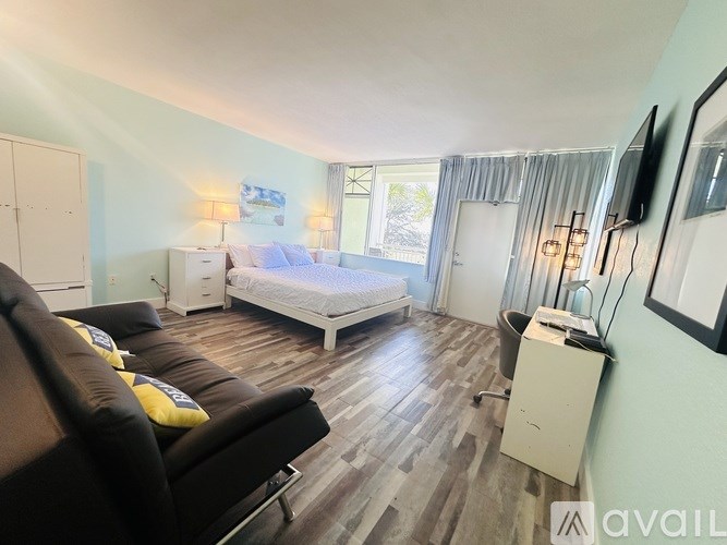 A bedroom with a bed, a couch, and a TV.