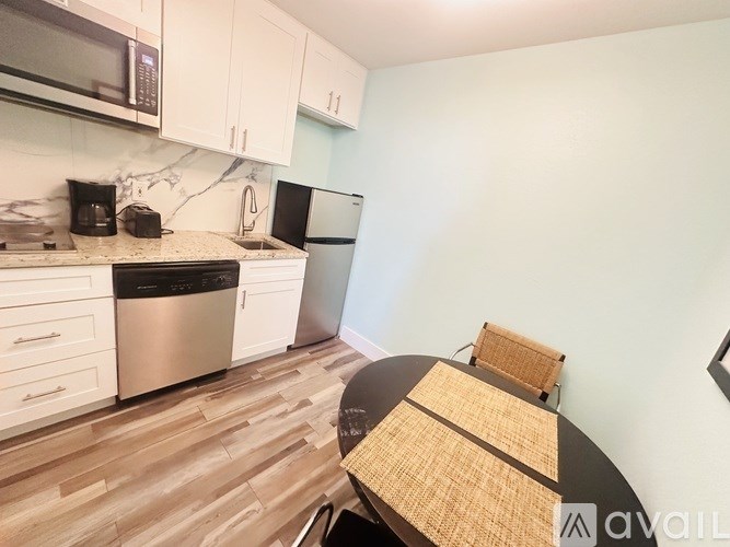 A kitchen with a black fridge and a black dishwasher.