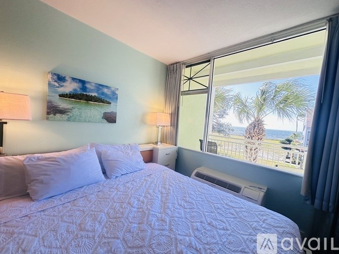 A bedroom with a large bed and a view of the ocean through the window.
