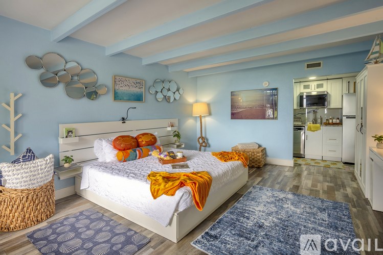 A bedroom with a bed, a chair, and a rug.