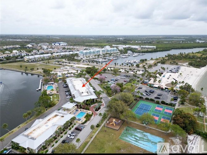 A large building with a pool in front of it is highlighted by an arrow.