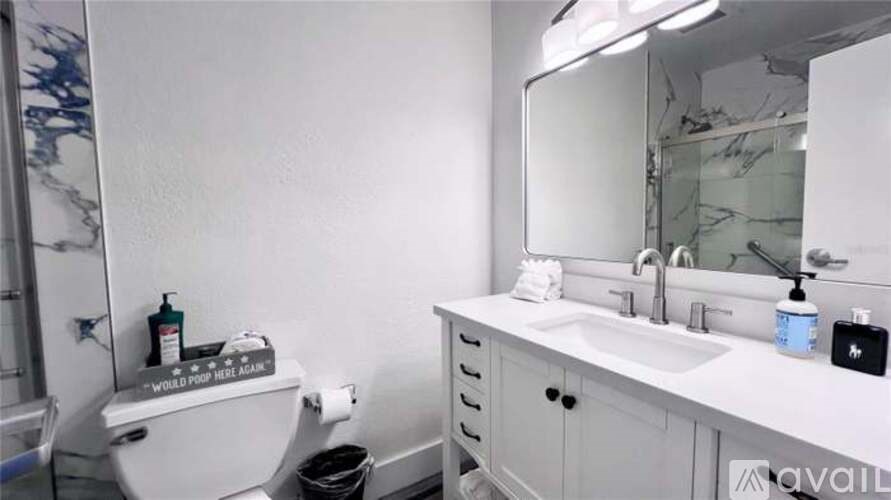 A bathroom with a toilet, sink, and mirror.