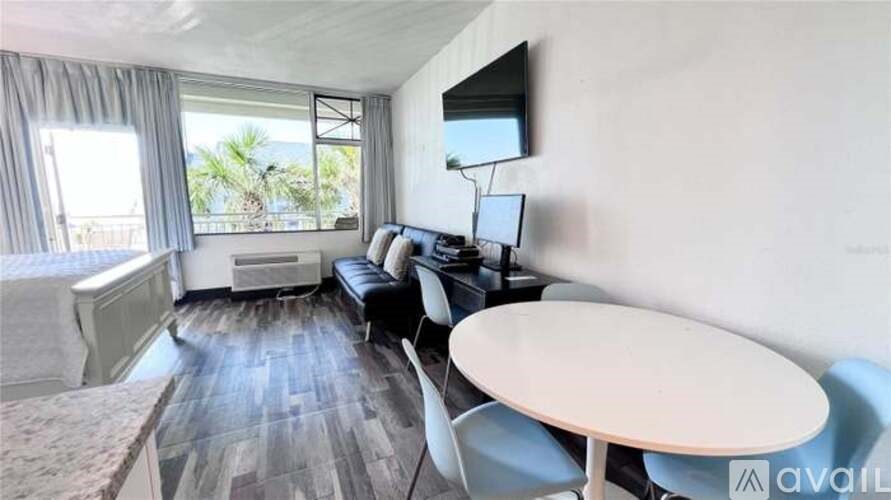 A living room with a sofa, chairs, and a television.