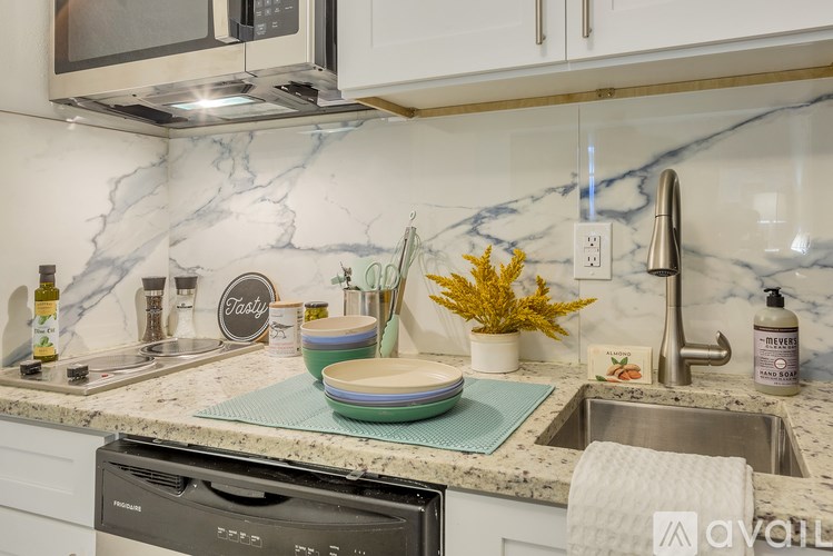A kitchen counter with a marble backsplash and a dishwasher.