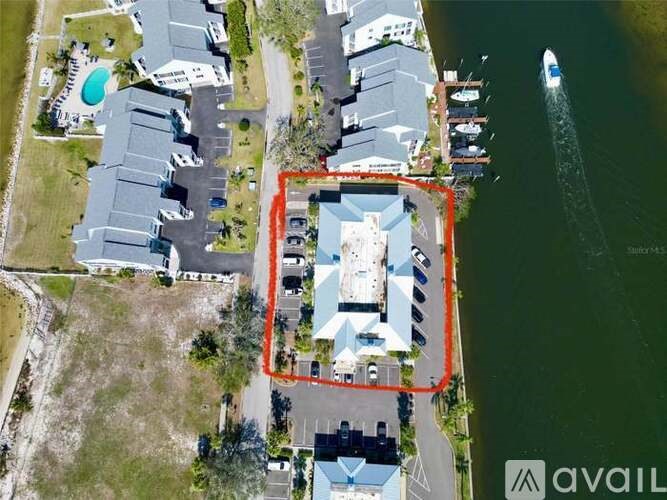 A bird's eye view of a property with a large building and a boat in the water.