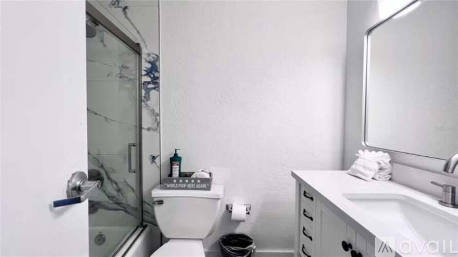 A bathroom with a toilet, sink, and mirror.