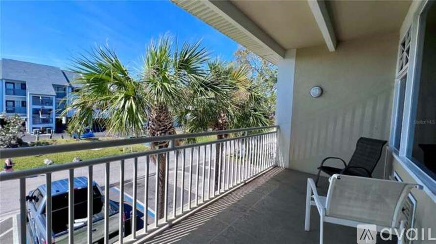 A balcony with a chair and a palm tree.
