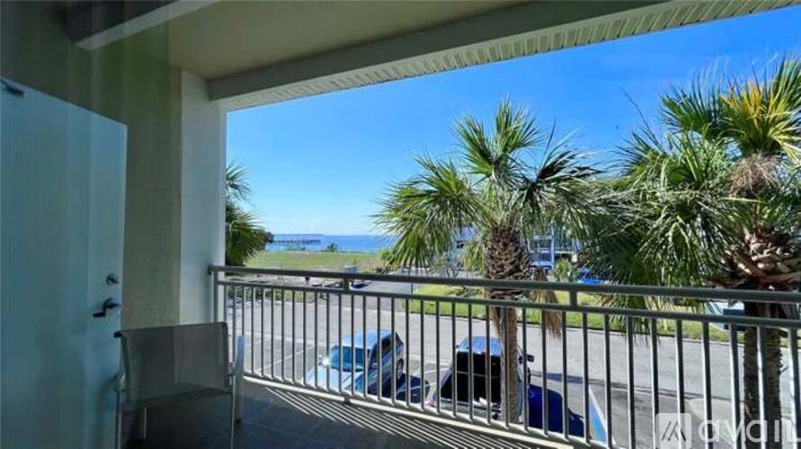 A balcony with a chair and a view of the ocean.