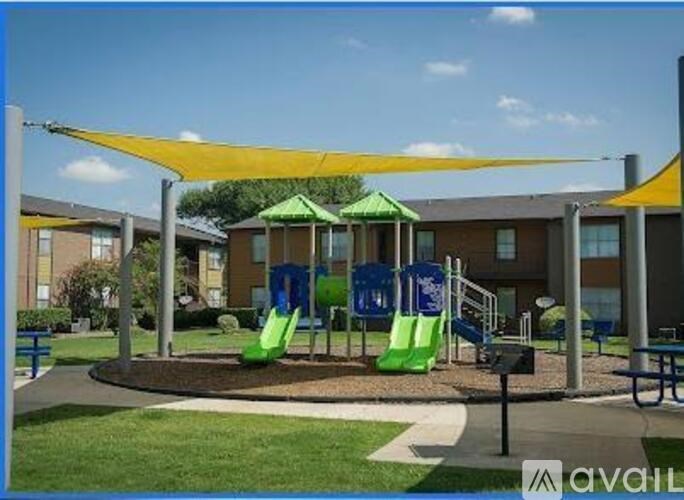 A playground with a yellow canopy and a green slide.