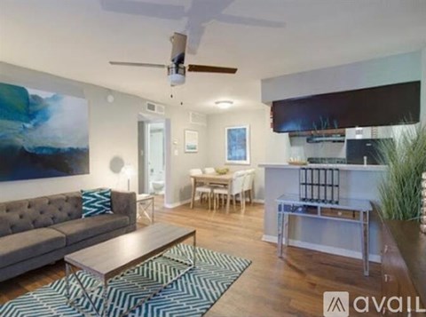 A living room with a grey couch, a coffee table, and a painting on the wall.