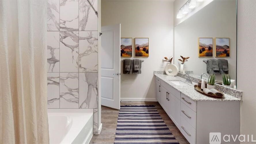 A bathroom with a marble patterned shower curtain and a white bathtub.