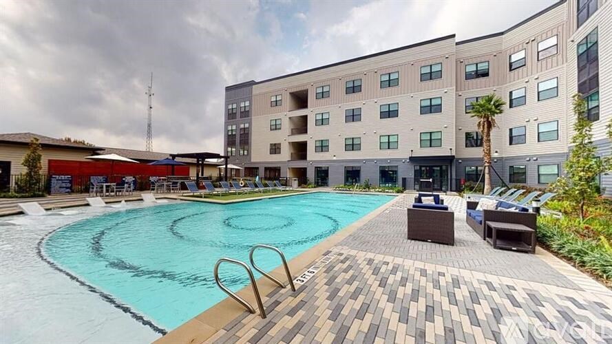 A large outdoor swimming pool with a wooden deck and lounge chairs.