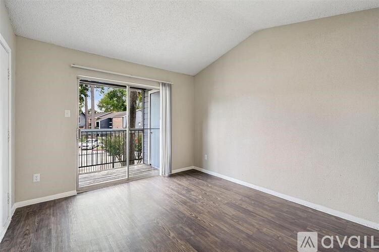 Empty room with a sliding glass door leading to a balcony.